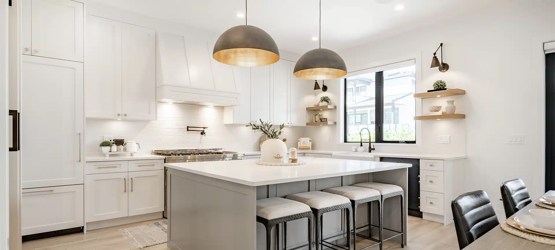 A modern kitchen island with sculptural, brass statement pendant lights, a top kitchen lighting trend 2025